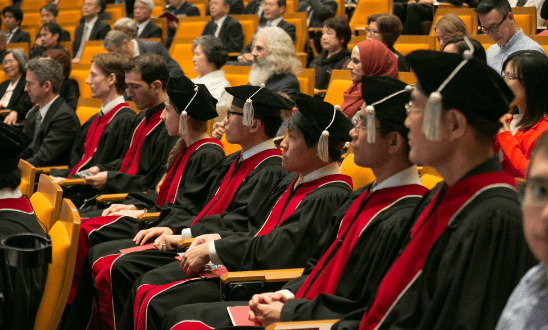 Students in robes sitting in the front row.