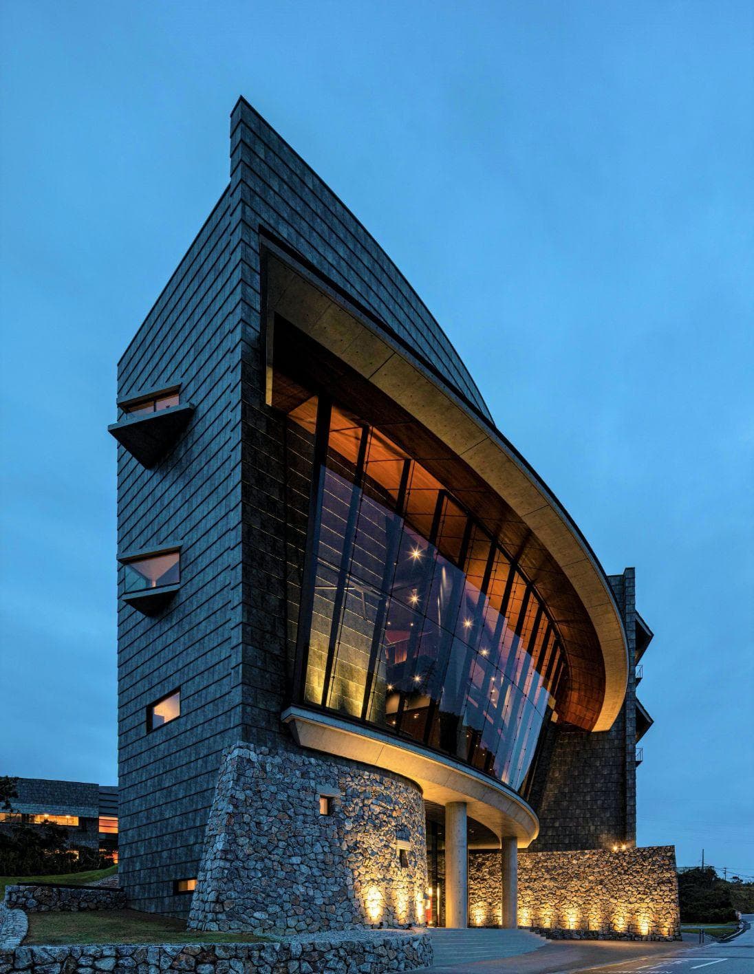 Angular with a curved glass front, Lab 4 entrance facade rises into the night sky.